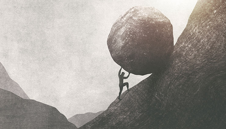 Man pushing a boulder up a hill