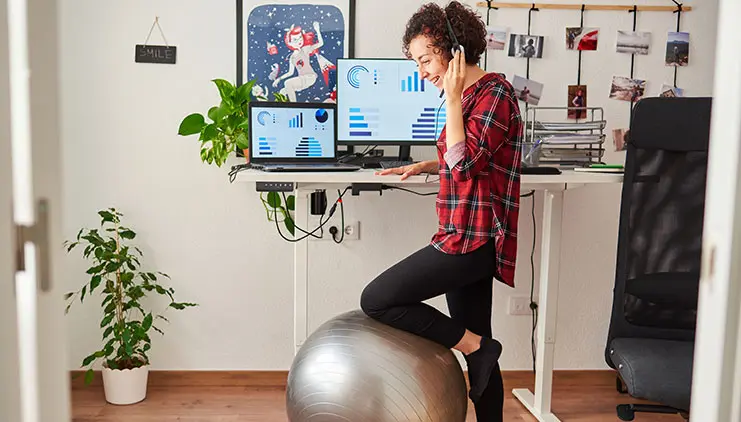 Home office worker using an exercise ball as a chair for well-being